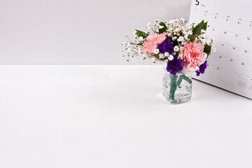 Flowers are placed in a recycled pet bottle with a calendar