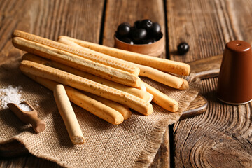 Board with tasty Italian Grissini on wooden background
