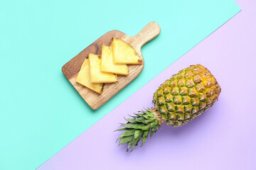 Wooden board with fresh cut pineapple on color background
