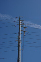 Electricity distribution pylon and power lines under blue sky