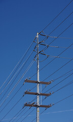 Electricity distribution pylon and power lines under blue sky