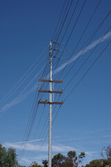 Fototapeta premium Electricity distribution pylon and power lines under blue sky