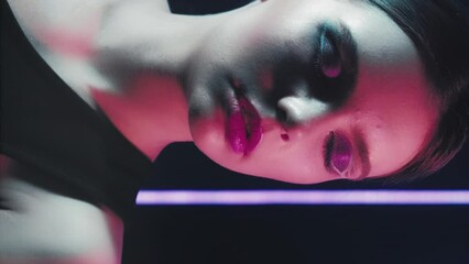 Vertical video. Retro fashion. 90s girl. Night beauty look. red Purple blue color neon flash light relaxed teen model face with artistic makeup closed eyes posing on dark. - Powered by Adobe
