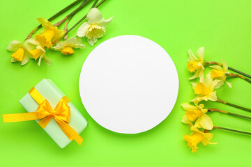 Beautiful narcissus, gift box and round blank card on color background