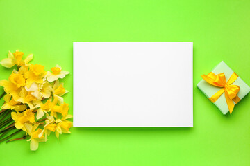 Beautiful narcissus, gift box and rectangular blank card on color background