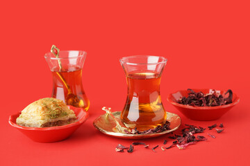 Glasses of tea with Turkish delight on red background