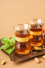 Tray with glasses of Turkish tea on beige background