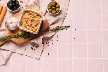 Bowl with tasty hummus on pink tile background
