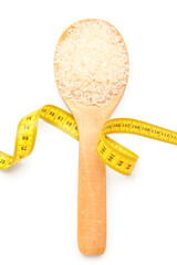 Wooden spoon with rice and yellow measuring tape on white background. Diet concept