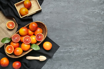 Wicker basket with tasty blood oranges on dark background