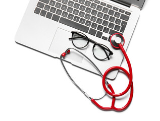 Stethoscope, laptop and glasses on white  background