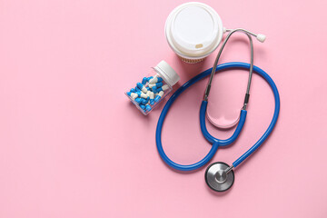 Fototapeta premium Stethoscope, coffee and pills on pink background