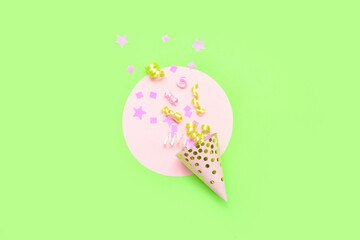 Composition with party hat and confetti on green background