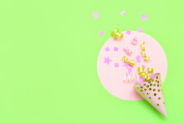 Composition with party hat and confetti on green background