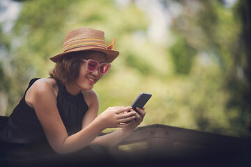 beautiful woman reading message in smart phone and smiling with happiness