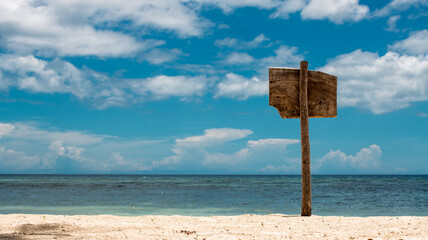 wooden sign on the beach of a tropical island, against the background of the sky and the sea, advertising seasonal offers