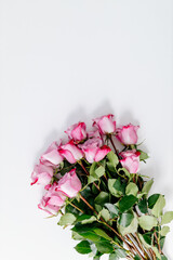 Bouquet of beautiful fresh pink roses on a white background. Fresh flowers on a white canvas. Place for text. Mock up. Gift for Mother’s Day, International woman’s day, Valentine’s Day.