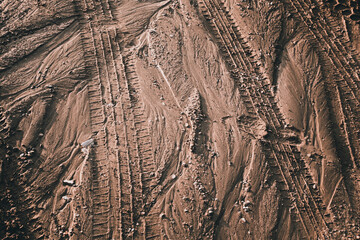 Close up of tire tracks through wet sand