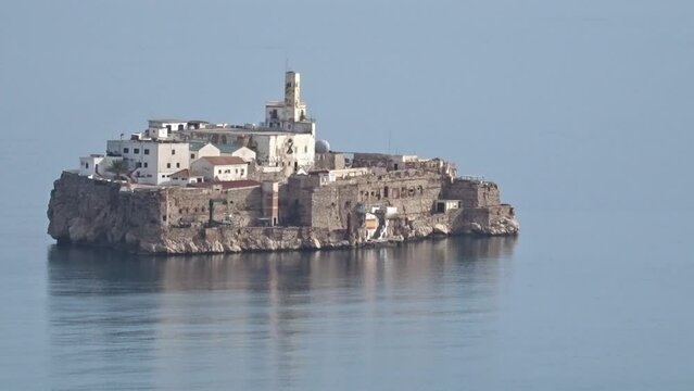 Rock of Alhucemas surrounded by fog. Isolated spanish military fortress in the Moroccan coast