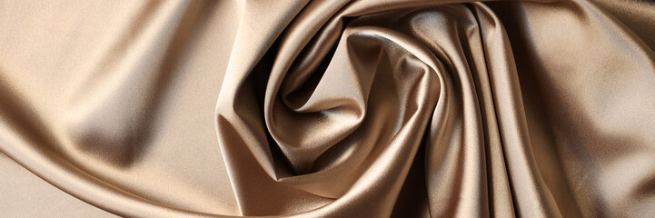 Beige satin fabric background. Texture of viscose is brown background
