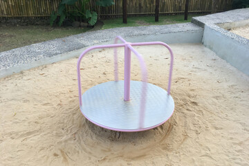 Children's pink carousel spins without people on the playground.