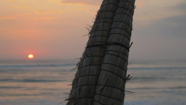 Traditional fishing boat on the beach at sunset, in Trujillo, Peru