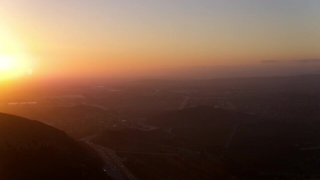 Aerial Backward Shot Of Cars Moving On Road By Mountains Against Sky During Sunset - Camarillo, California