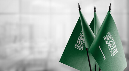 Small flags of the Saudi Arabia on an abstract blurry background