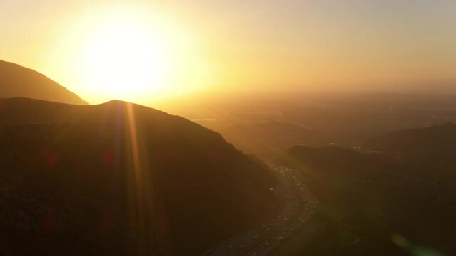 Aerial Scenic Shot Of Cars Moving On Roads, Drone Flying Backwards During Sunset - Camarillo, California