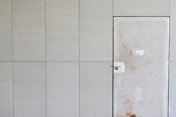 blank grey cement wall and rust steel door with hasp texture background, construction industry