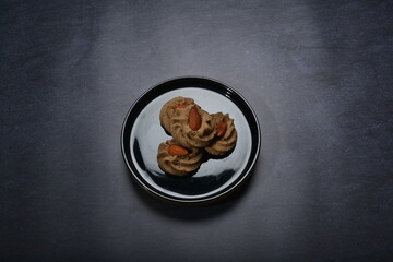 homemade halal quqi cookies with peanut, matcha, earl grey tea, almond green tea and icing sugar in round shape on black and gold luxury background handmade fresh bakery pastry halal menu