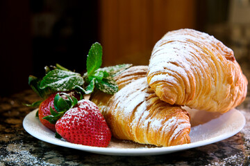 Croissant stuffed with curd cheese, strawberries and strawberry jam lying on a wooden board. High quality photo
