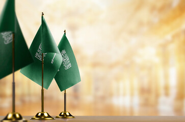 Small flags of the Saudi Arabia on an abstract blurry background