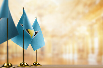 Small flags of the Saint Lucia on an abstract blurry background