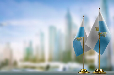 Small flags of the San Marino on an abstract blurry background