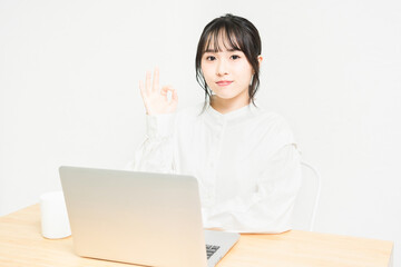 PCを使いながらOKをする若い女性