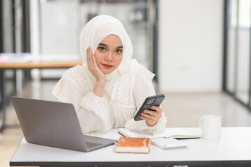 Young islamic Asian businesswoman holding notebook about business, spending money