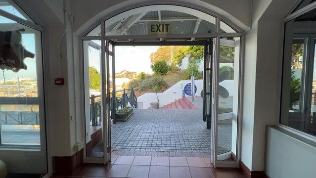 A small mall entrance with steps and trees blowing in the wind