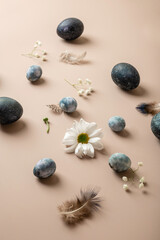 Stylish Easter composition with blue Easter eggs and flowers on a gentle background. Copy space, top view, flat lay. Easter concept