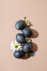 Stylish Easter composition with blue Easter eggs and flowers on a gentle background. Copy space, top view, flat lay. Easter concept