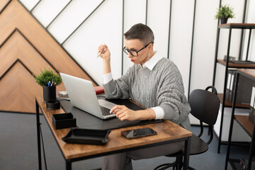 Naklejka premium portrait of an office worker in a company sitting at a desktop with a laptop