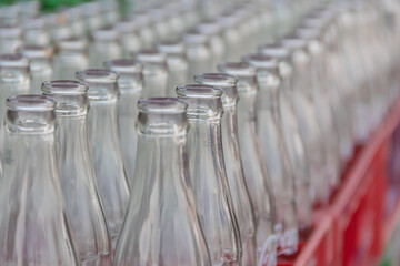 Empty glass bottles waiting for cleaning in factory to fill with drink.