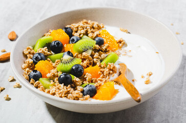 Yogurt with Granola, Kiwi, Blueberries, and Orange in a Bowl, Healthy Snack or Breakfast