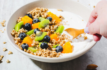 Yogurt with Granola, Kiwi, Blueberries, and Orange in a Bowl, Healthy Snack or Breakfast
