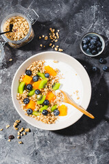 Yogurt with Granola, Kiwi, Blueberries, and Orange in a Bowl, Healthy Snack or Breakfast