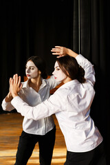 Young actress in a costume with white make-up in the rehearsal theater