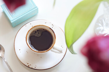 A cup of black coffee stands on a table