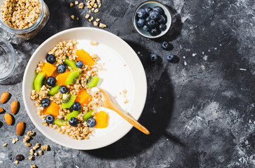 Yogurt with Granola, Kiwi, Blueberries, and Orange in a Bowl, Healthy Snack or Breakfast
