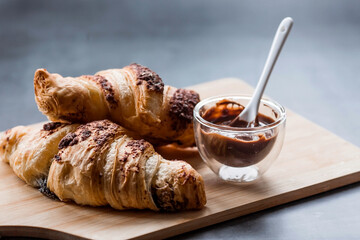 Delicious freshly baked croissants with chocolate on a dark background. French breakfast. Delicious pastries close-up. The context of a bakery with delicious bread. Confectionery products.