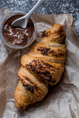 Delicious freshly baked croissants with chocolate on a dark background. French breakfast. Delicious pastries close-up. The context of a bakery with delicious bread. Confectionery products.